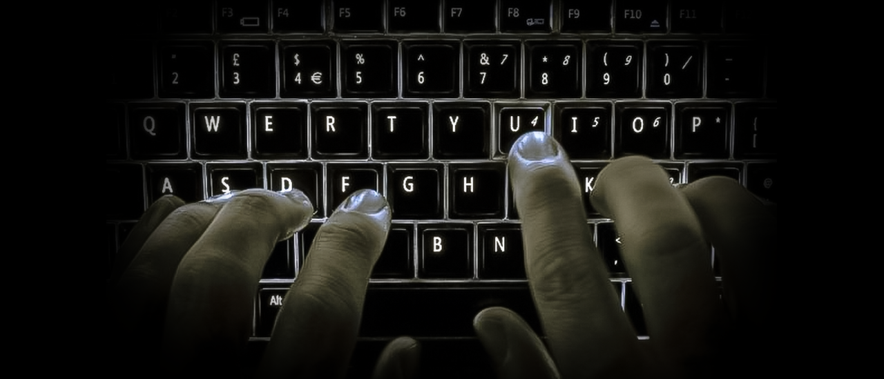 Je ziet van bovenaf vingers die typen op een toetsenbord